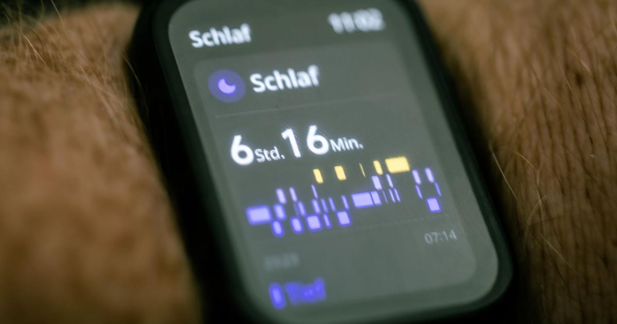 Close-up of a wrist-worn fitness tracker screen displaying a sleep summary with total sleep time and a sleep-stage timeline.